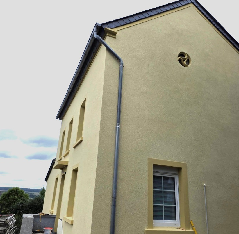 Façade jaune rénovée d’une maison au Luxembourg